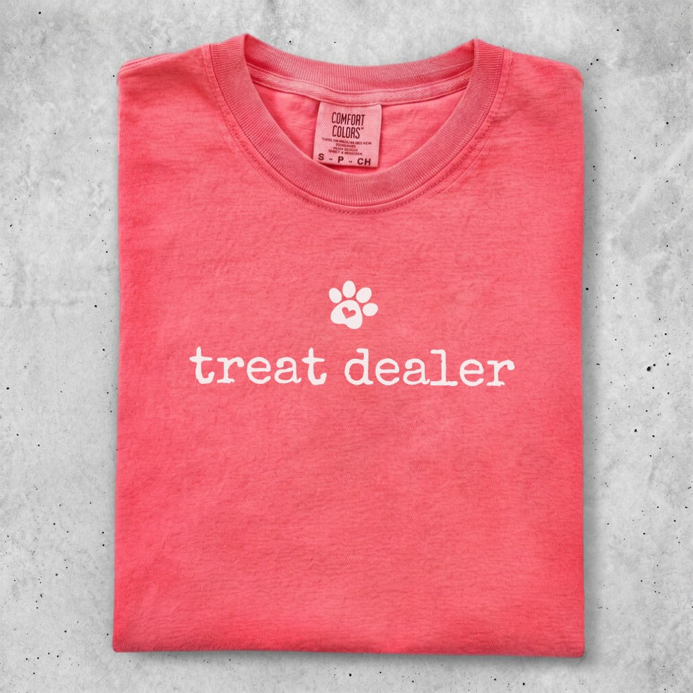 Coral t-shirt with "treat dealer" and a paw print graphic.