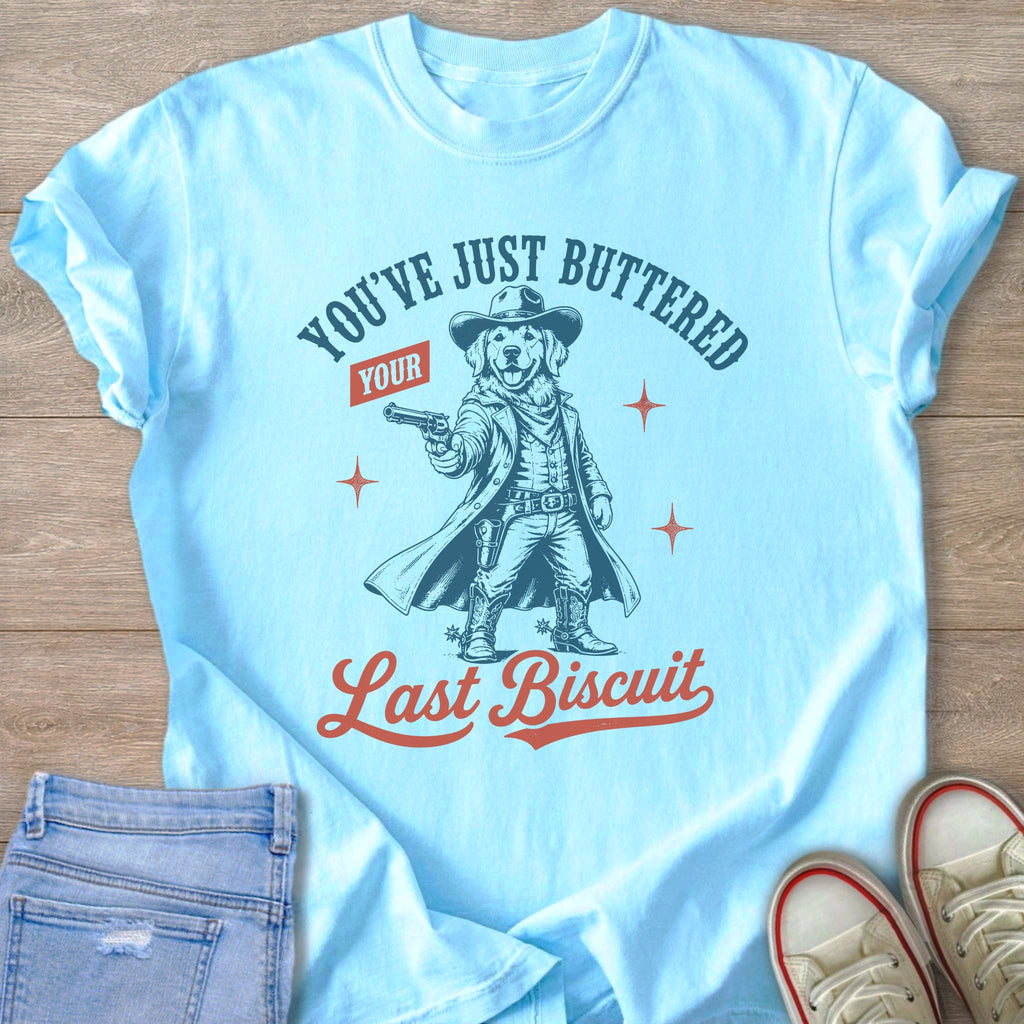 Light blue t-shirt with graphic of a dog in cowboy attire holding a gun.