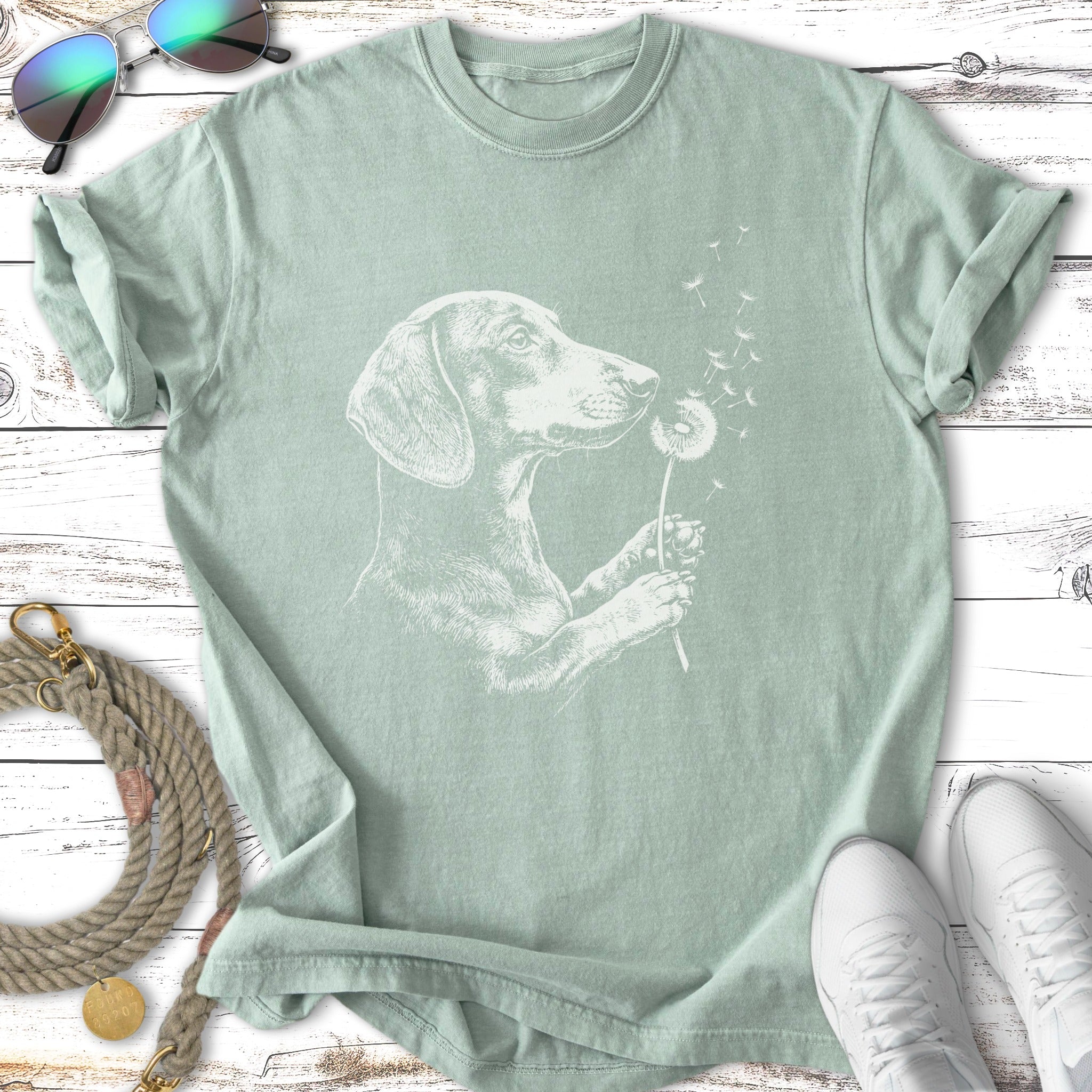 Dachshund with dandelion fluff on light green t-shirt.