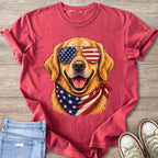 Golden retriever wearing American flag sunglasses and bandana on red t-shirt.