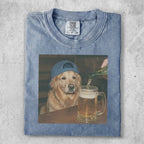 Golden retriever wearing a blue cap being poured beer from a bottle.