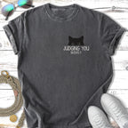 Black t-shirt with "JUDGING YOU SILENTLY." and a cat's eyes graphic.
