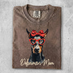 Doberman wearing heart glasses and a red bow, "Doberman Mom" text.
