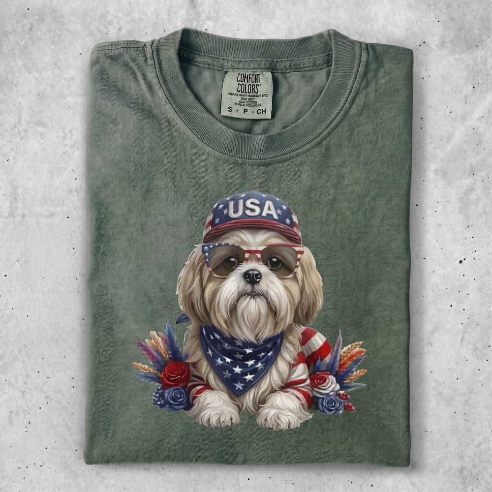 Dog wearing sunglasses and a bandana, with USA hat and floral accents.