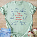 Mint green t-shirt with blue dachshund illustrations and text: "less meanies more weenies."