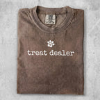 Brown Comfort Colors t-shirt with "treat dealer" and a paw print graphic.