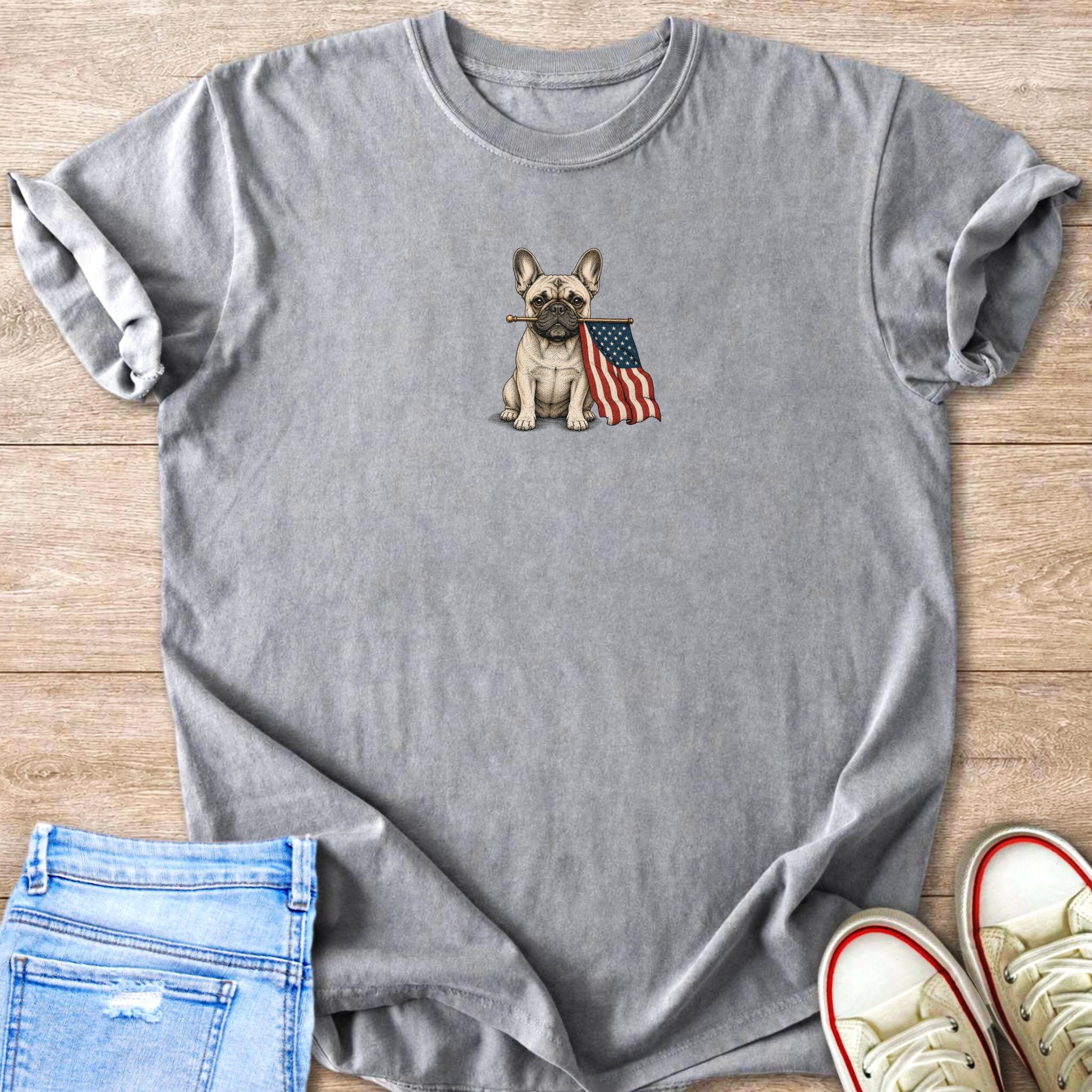 French bulldog wearing a bandana and holding an American flag in its mouth.