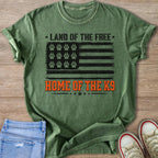 Green t-shirt with American flag graphic featuring paw prints, text "Land of the Free, Home of the K9".