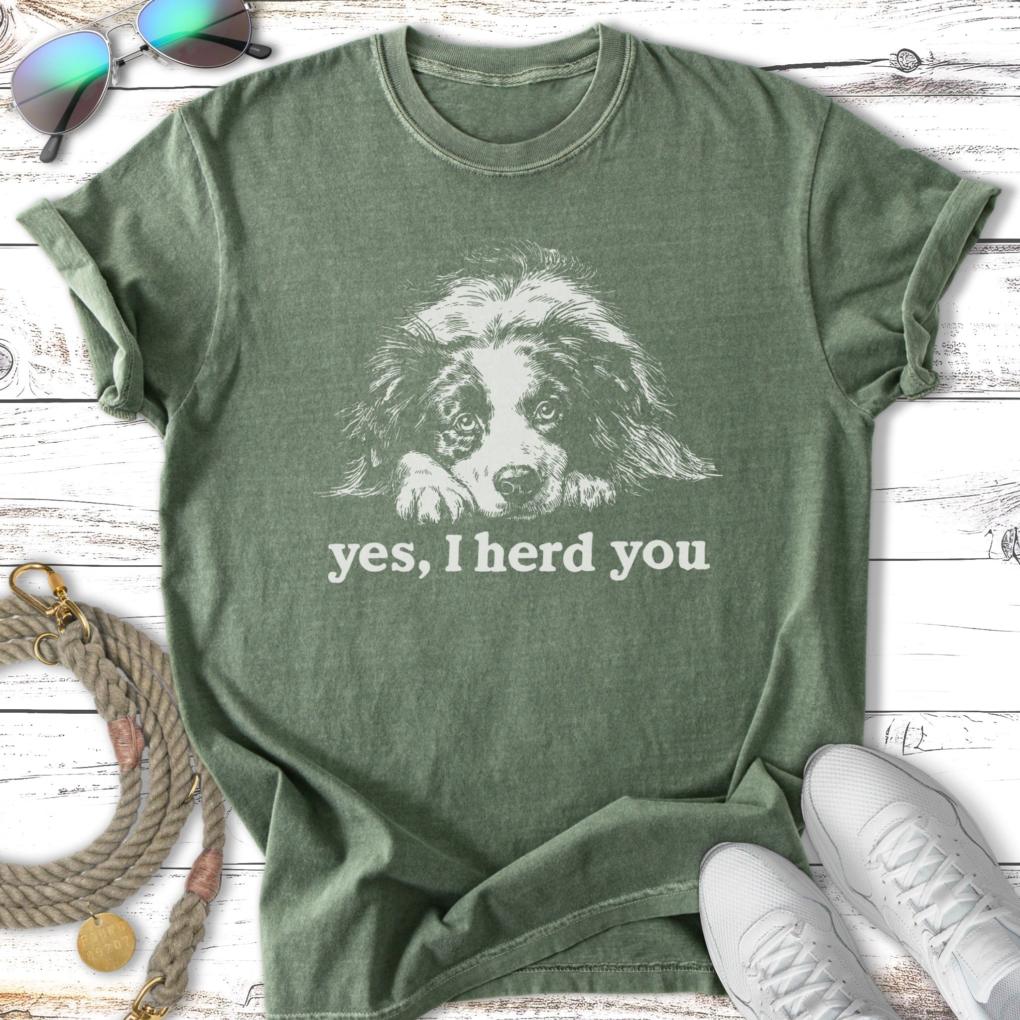 Green t-shirt with a white dog illustration and "yes, I herd you" text.