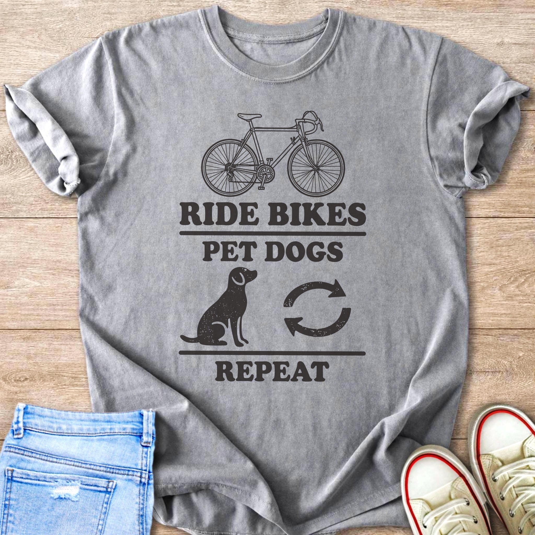 Grey t-shirt with black graphic: bicycle, dog, repeat arrows, and text.