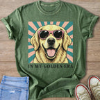 Green t-shirt with golden retriever wearing pink sunglasses, text "IN MY GOLDEN ERA"