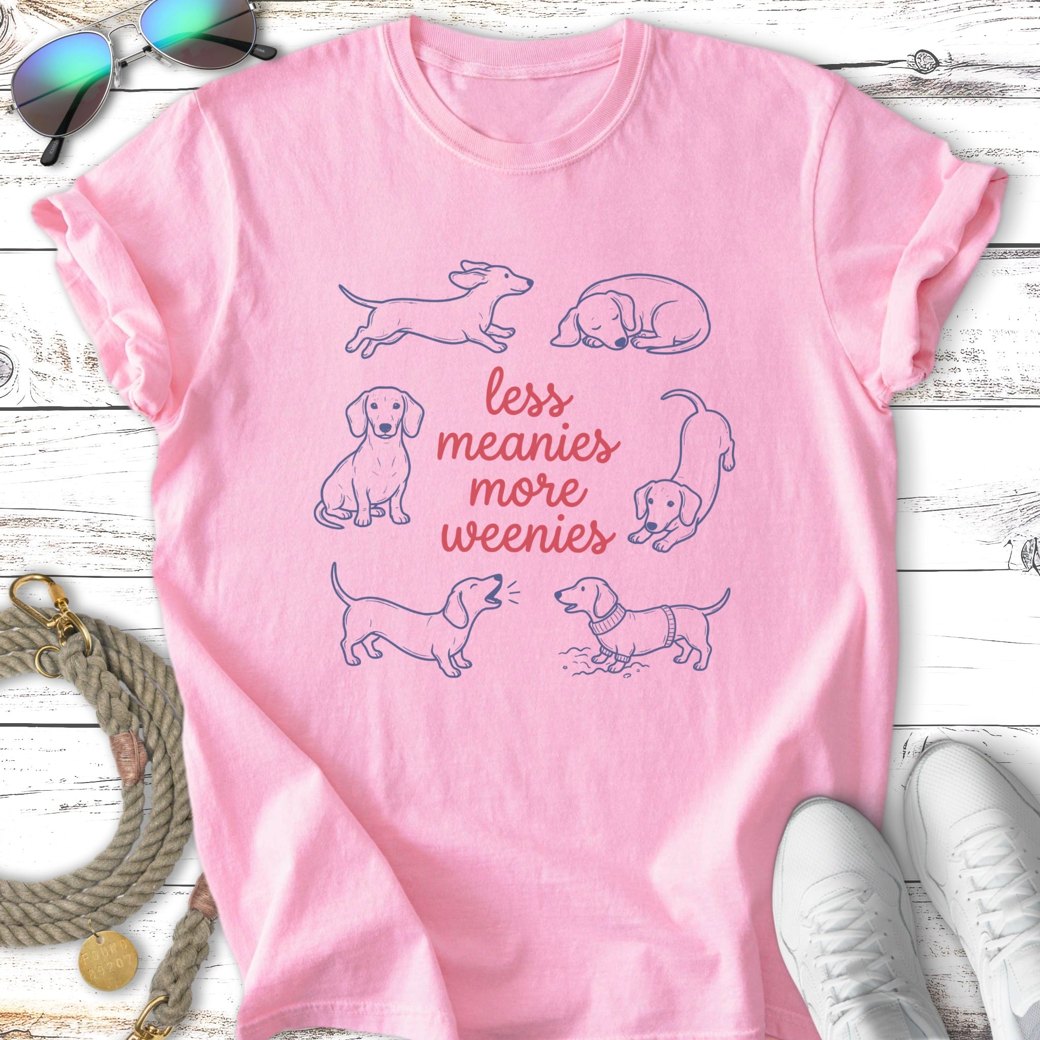 Pink t-shirt with a graphic of six dachshunds and the text "less meanies more weenies."