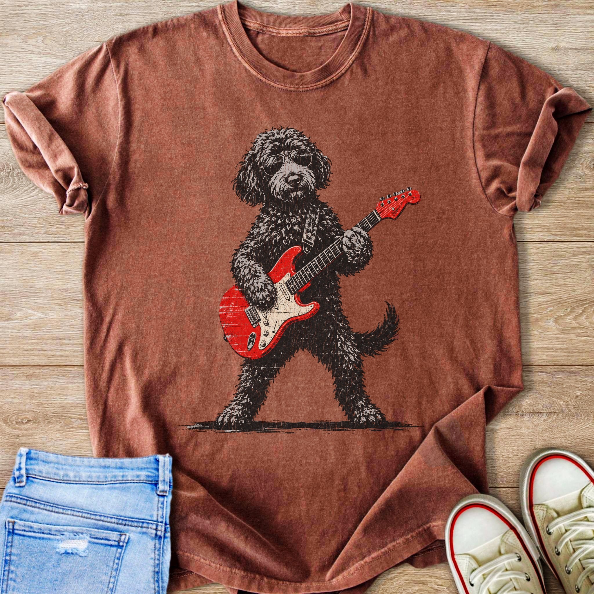 Brown t-shirt with graphic of a dog wearing sunglasses playing a red electric guitar.