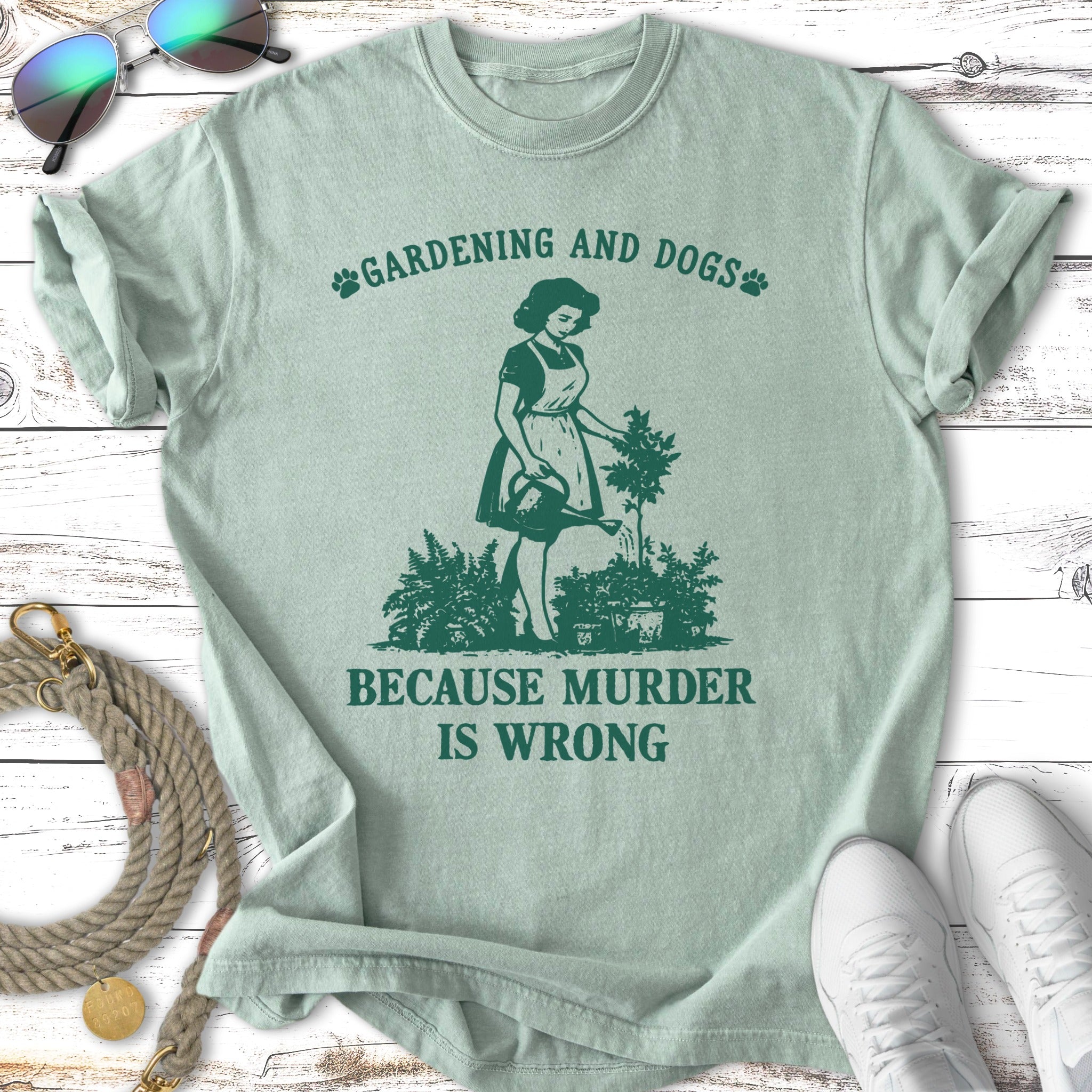 Green t-shirt with a woman gardening and text "Gardening and Dogs Because Murder Is Wrong".