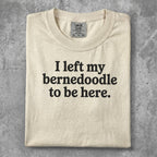 Cream t-shirt with "I left my bernedoodle to be here." text.