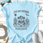 Corgi wearing a cowboy hat in a desert scene with text "I've got friends in low places".