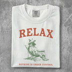 White t-shirt with "RELAX" and a dog in a chair, "NOTHING IS UNDER CONTROL".