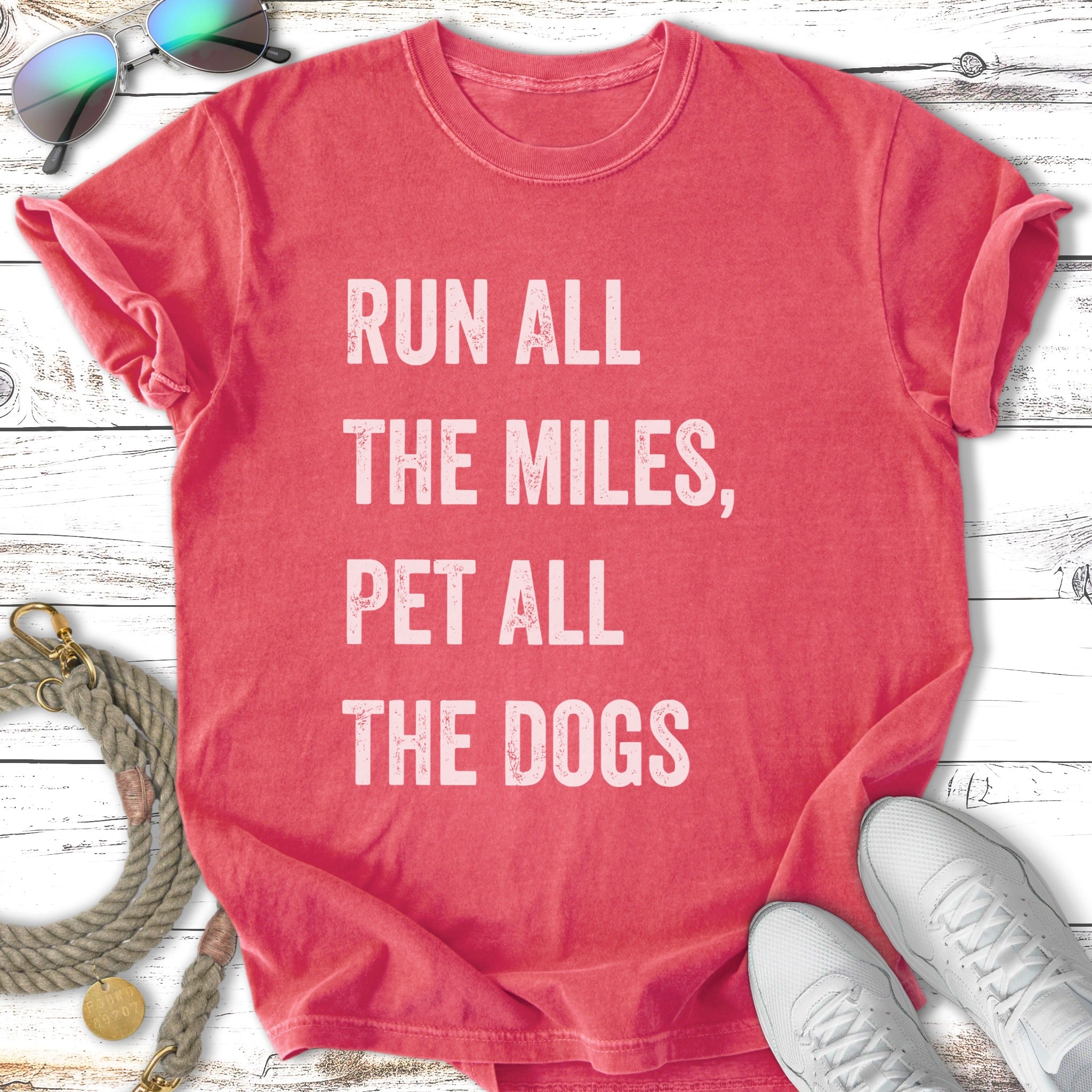 Coral t-shirt with "Run All The Miles, Pet All The Dogs" text.