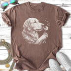 Golden retriever dog blowing dandelion seeds on a brown t-shirt.