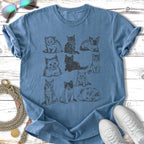 Line drawing of nine playful kittens on a blue t-shirt.