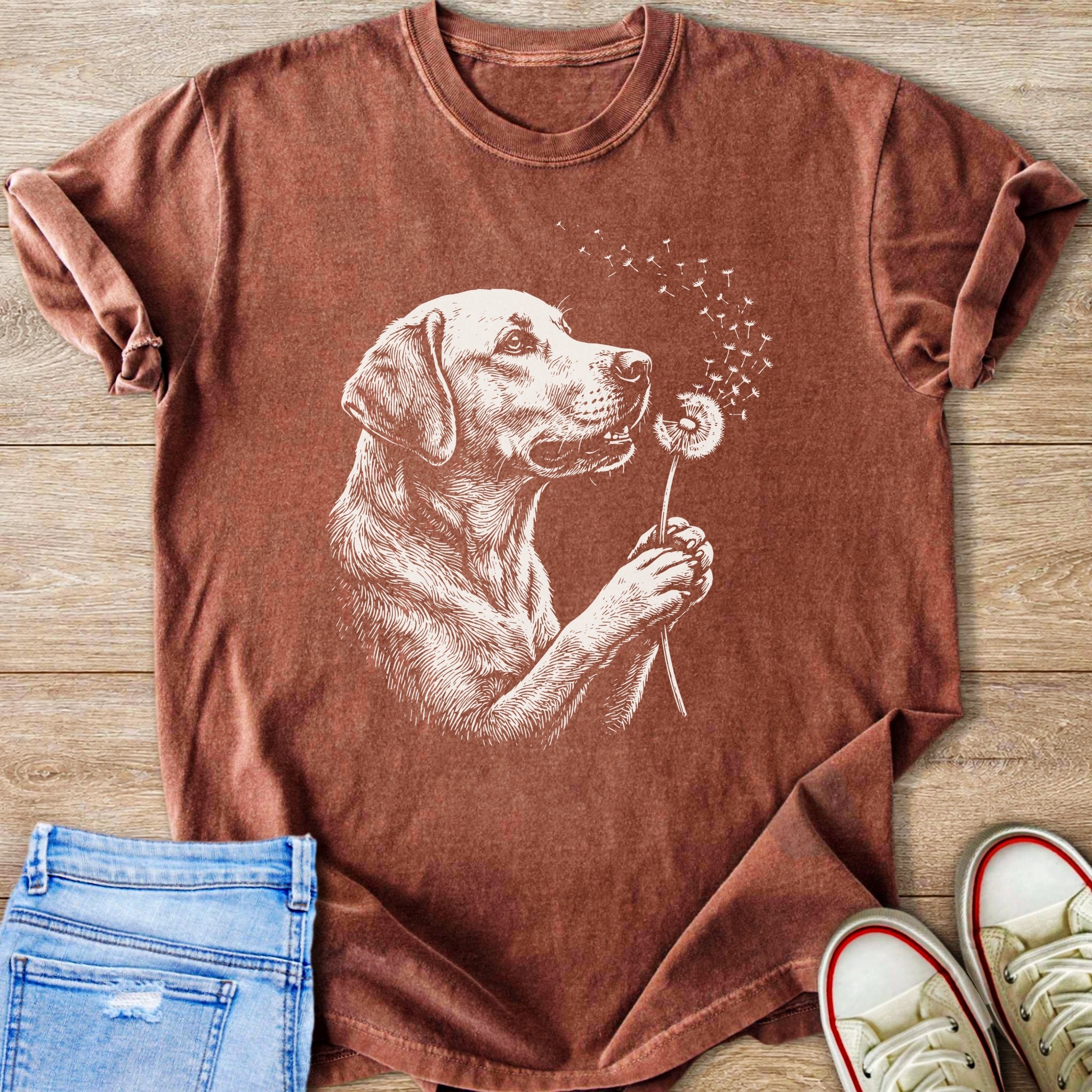 Brown t-shirt with white line art of a dog holding a dandelion.