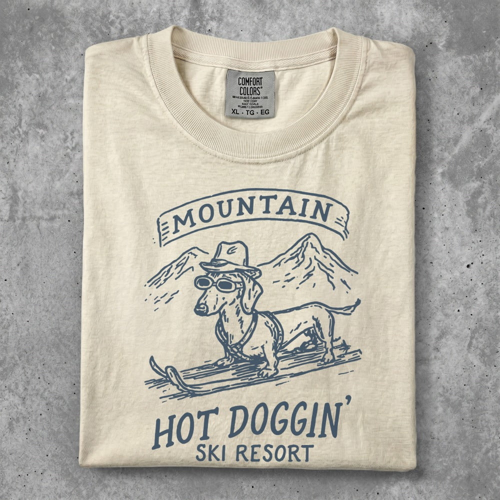 Dachshund in sunglasses on skis at "Hot Doggin' Ski Resort" vintage graphic.