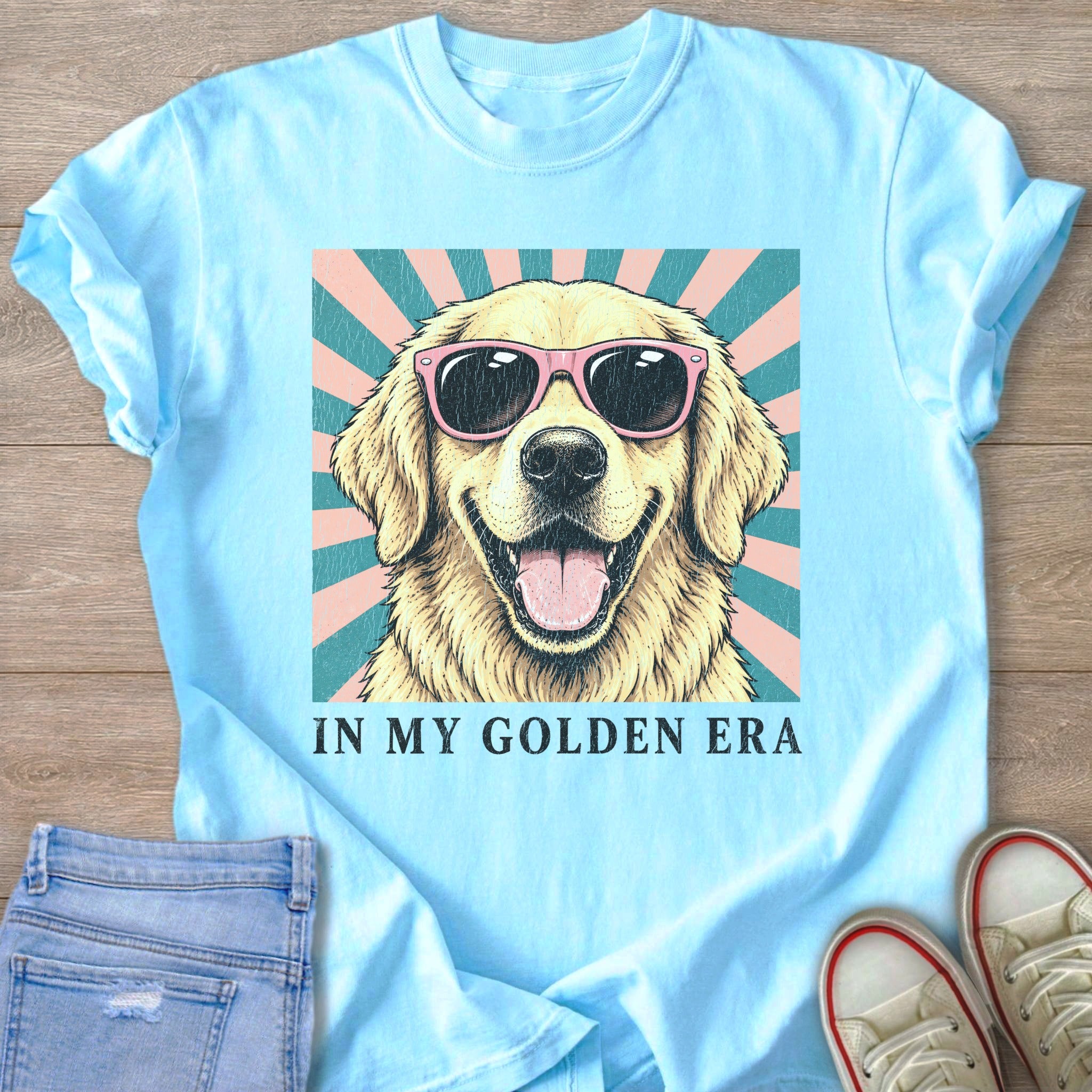 Light blue t-shirt with a smiling, sunglasses-wearing golden retriever graphic and text "IN MY GOLDEN ERA".