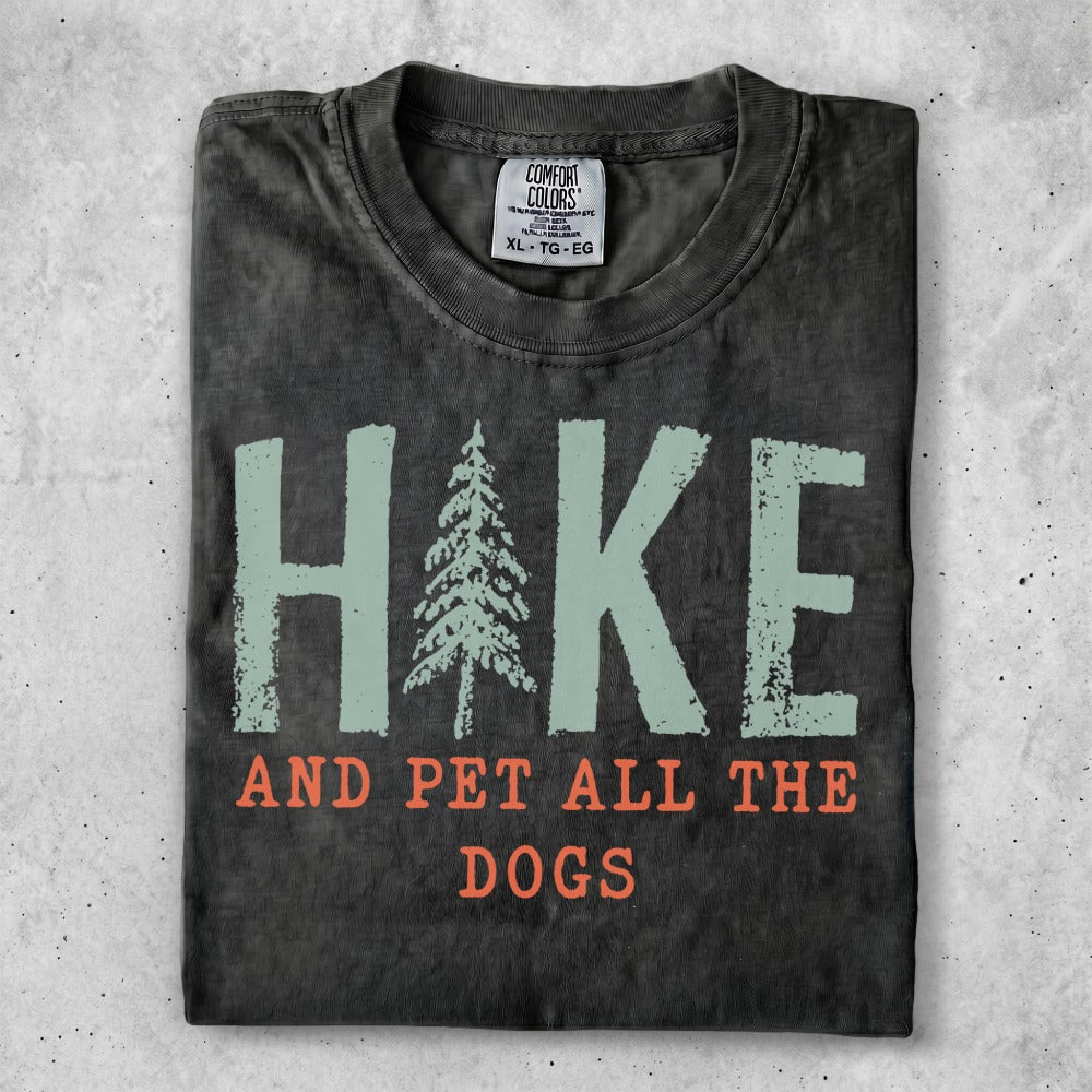 Dark t-shirt with "Hike and Pet All the Dogs" text and a pine tree graphic.