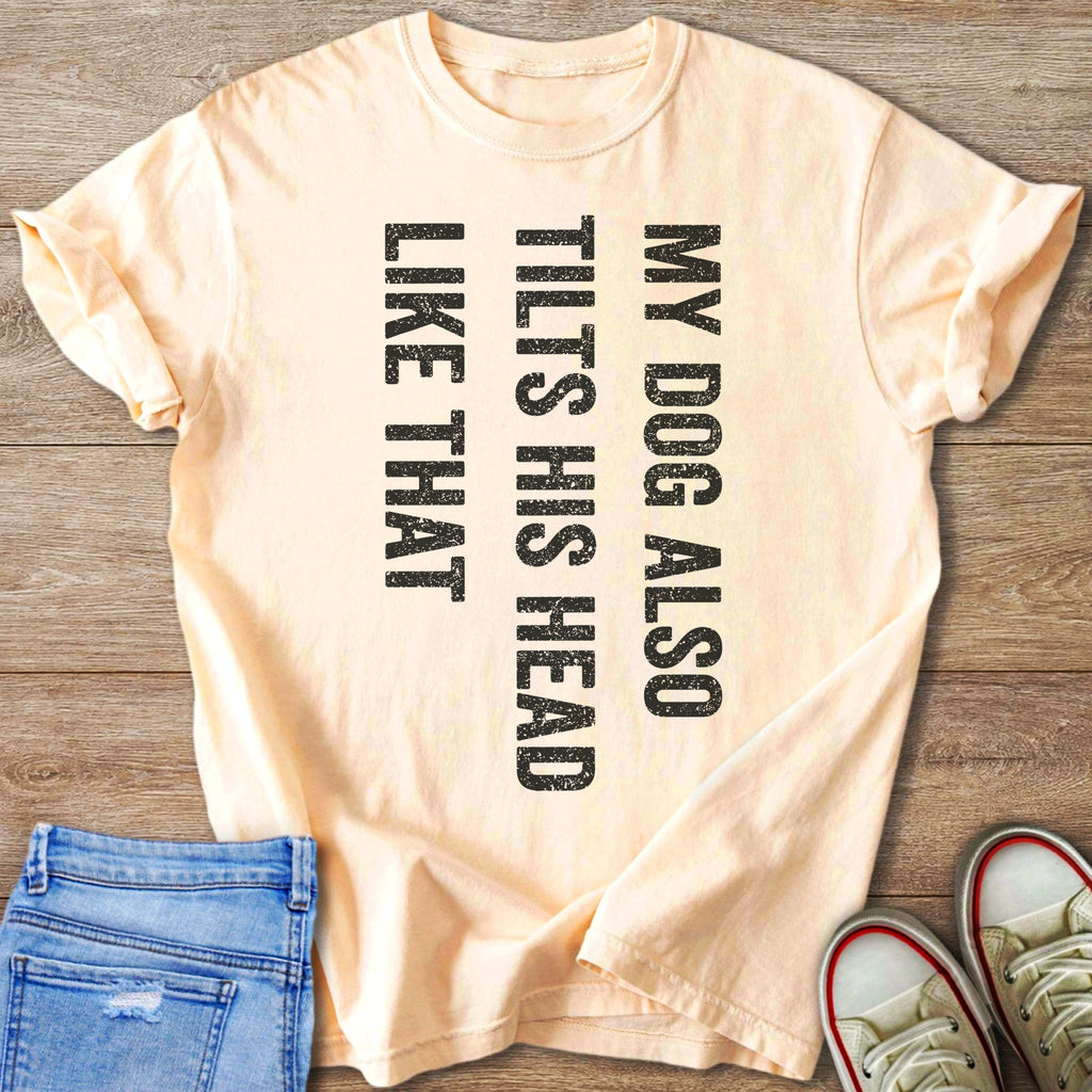 Peach t-shirt with black distressed text "MY DOG ALSO TILTS HIS HEAD LIKE THAT".