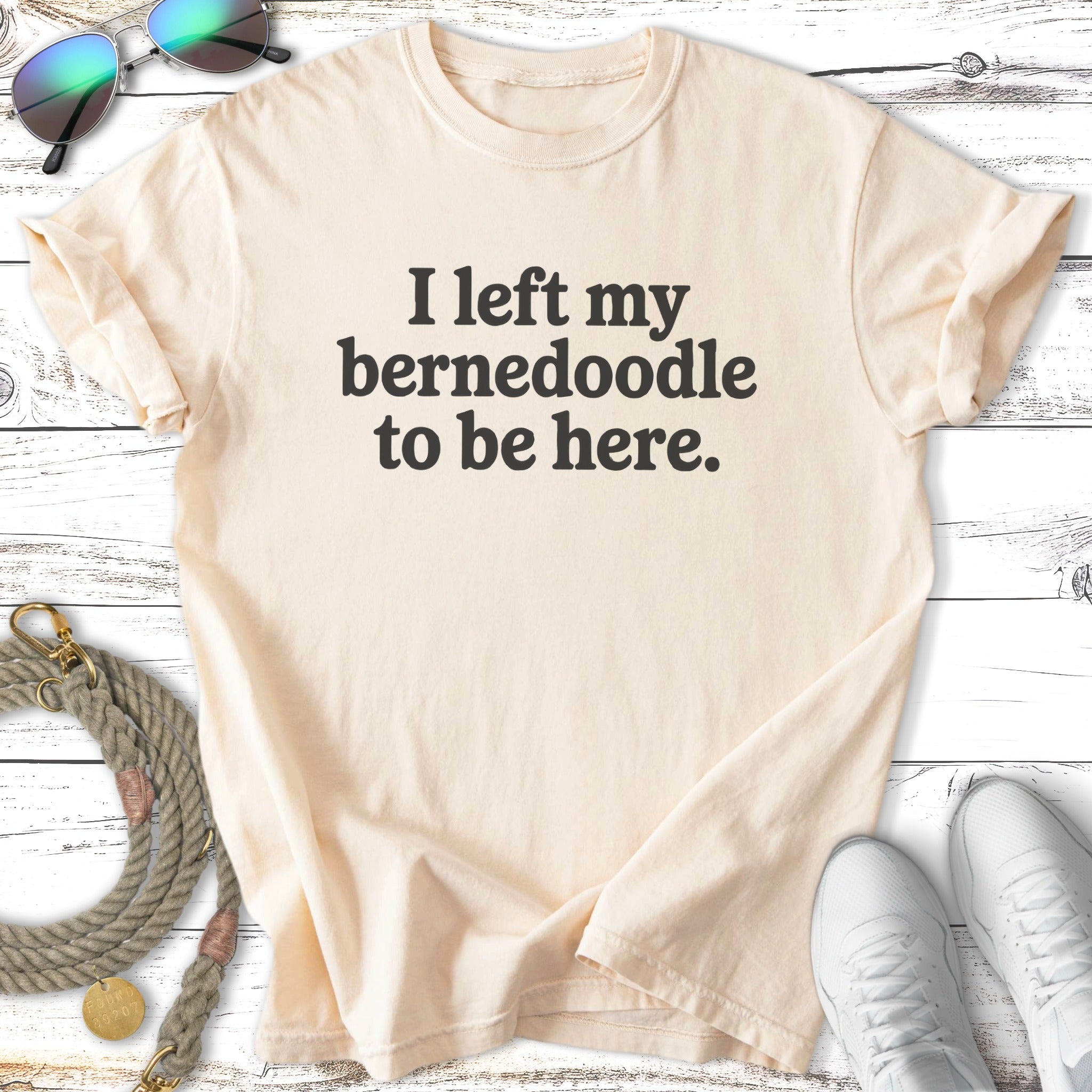 Cream t-shirt with "I left my Bernedoodle to be here." text.