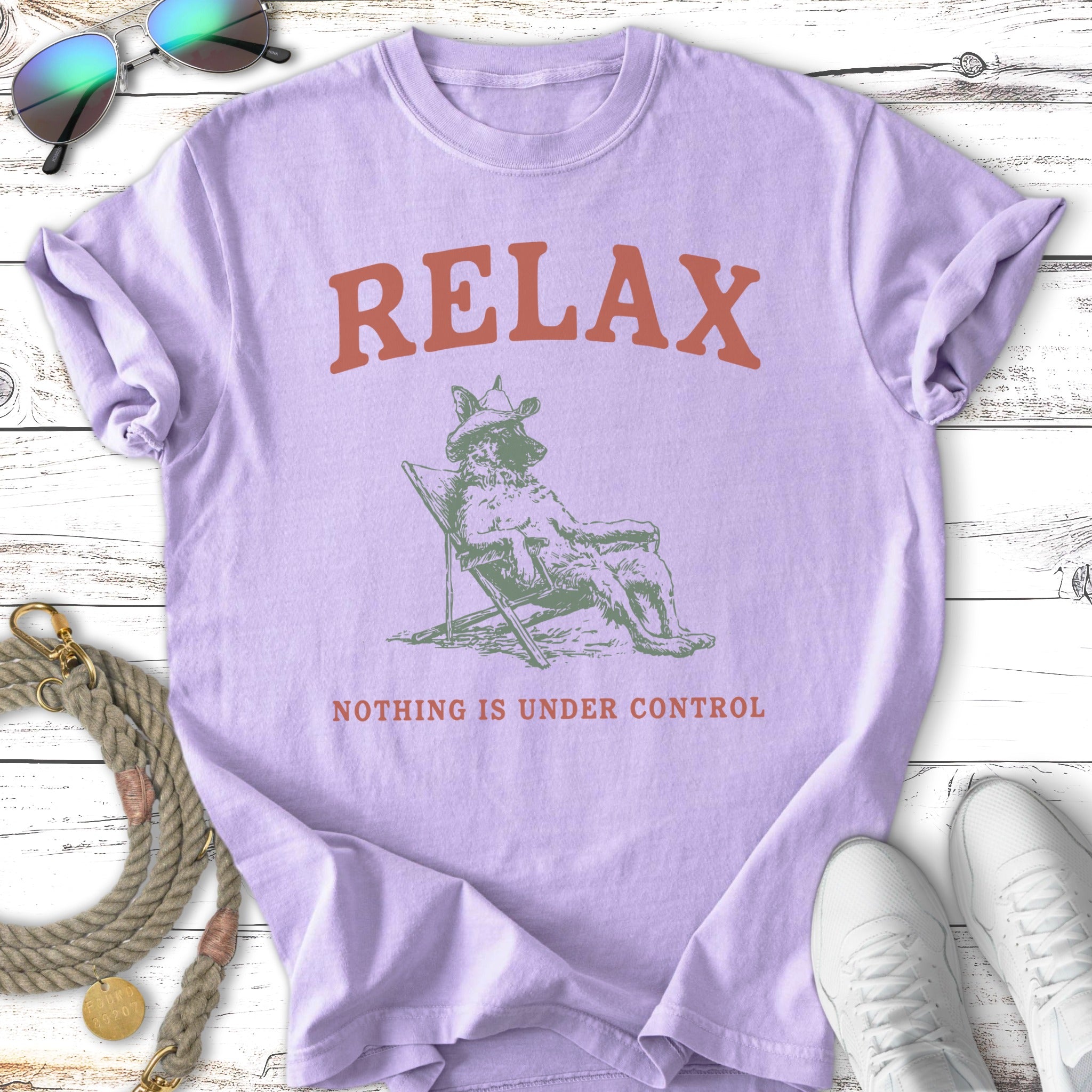 Purple t-shirt with "RELAX NOTHING IS UNDER CONTROL" text and dog illustration.