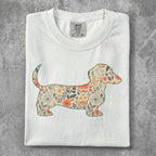 White t-shirt featuring a floral dachshund silhouette.