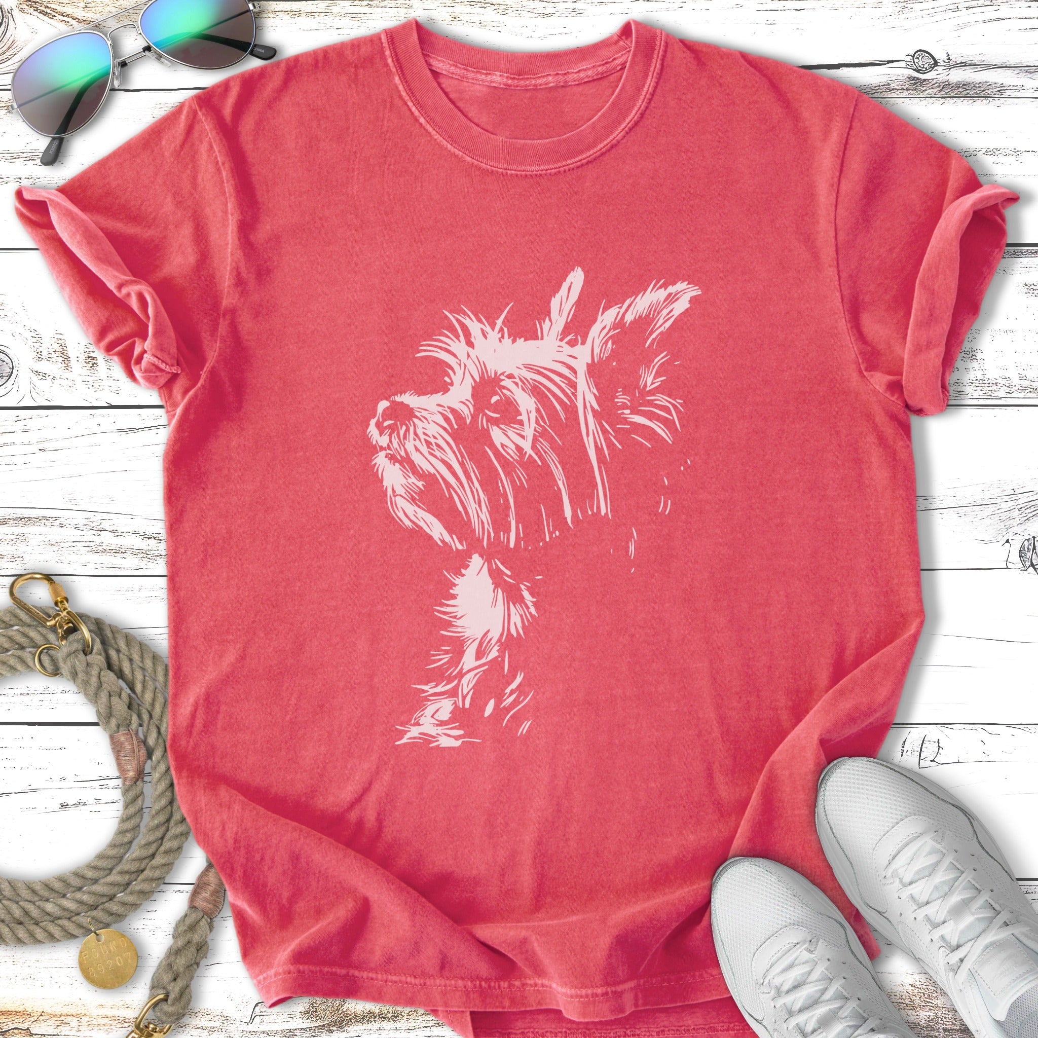Coral t-shirt with a white terrier dog graphic and sunglasses.