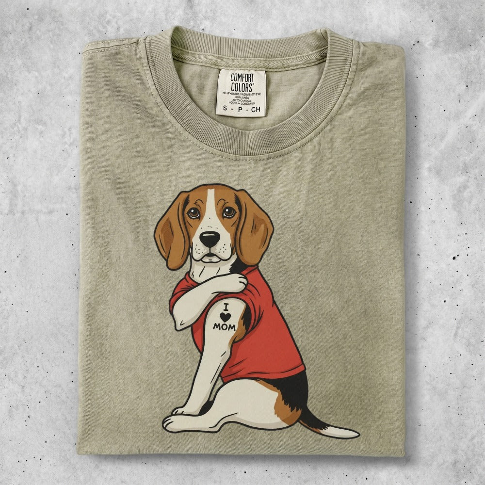 Beagle dog with "I <3 MOM" tattoo on arm, wearing red t-shirt.
