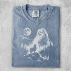 Pomeranian dog silhouette against moonlit forest scene on washed blue t-shirt.