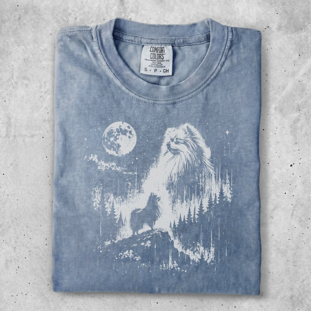 Pomeranian dog silhouette against moonlit forest scene on washed blue t-shirt.