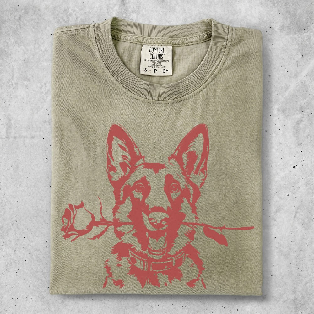 German Shepherd with rose in mouth on light olive green t-shirt.