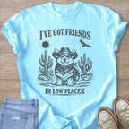 Light blue t-shirt with a graphic of a corgi wearing a cowboy hat and bandana in a desert scene.