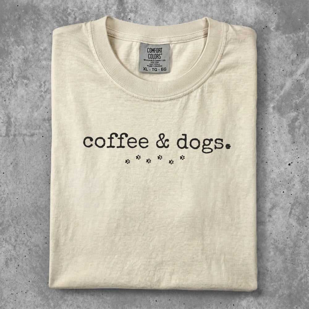 Cream t-shirt with "coffee & dogs." and paw prints graphic.
