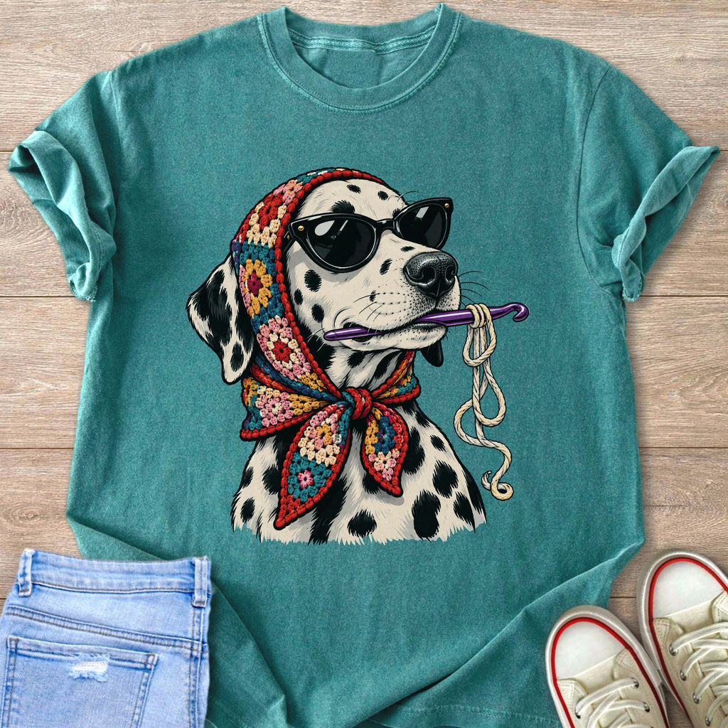 Dalmatian dog wearing sunglasses and a colorful crochet bandana holds a crochet hook.