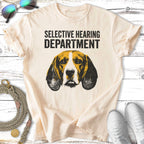 Beagle dog head graphic with "Selective Hearing Department" text on a cream t-shirt.