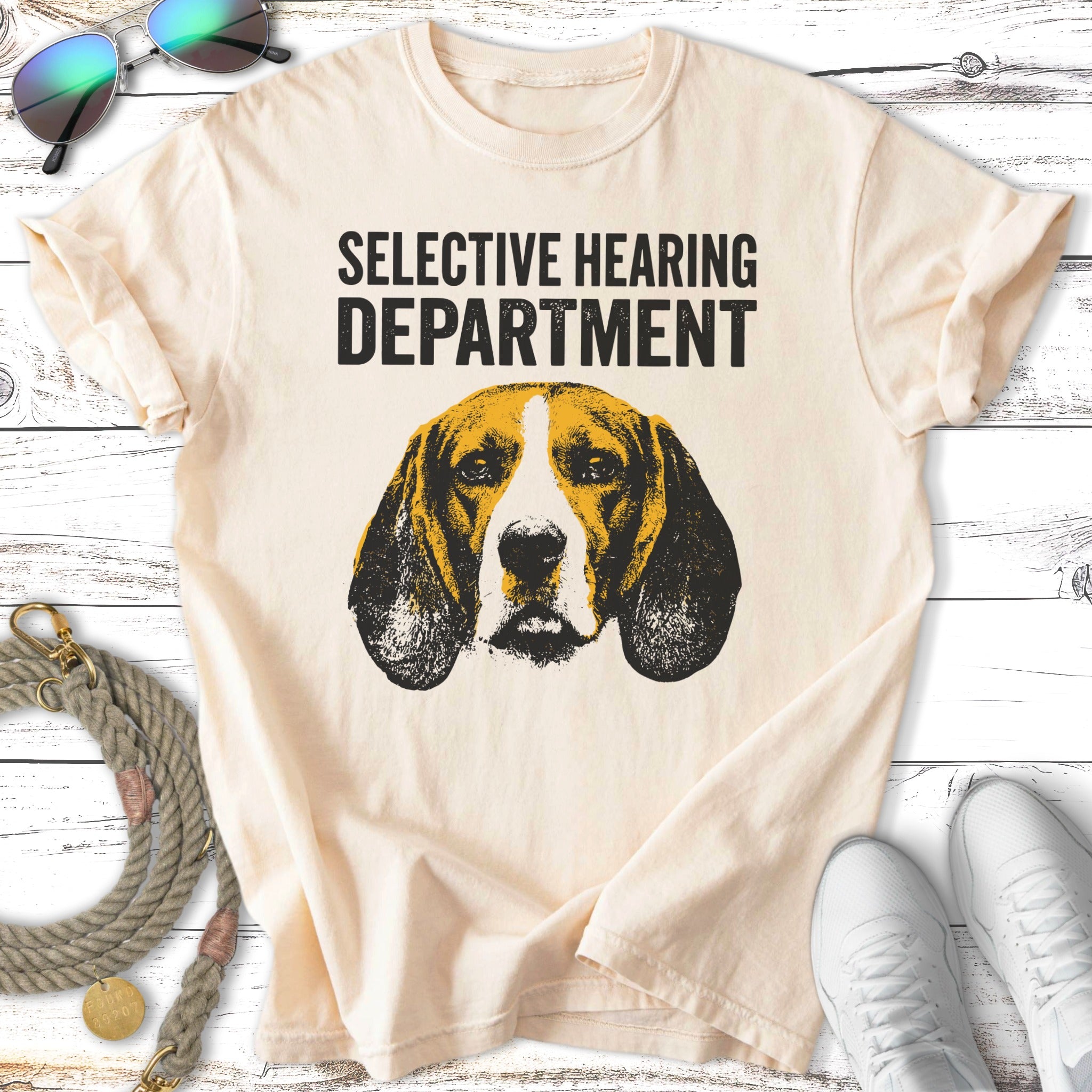Beagle dog head graphic with "Selective Hearing Department" text on a cream t-shirt.