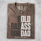 Brown t-shirt with bold white text: "BOLD BADASS DOG DAD that's just who I am!".