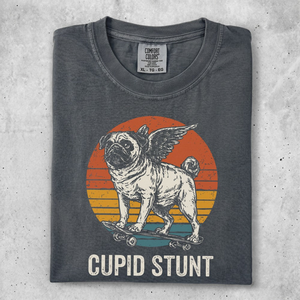 Pug with wings on a skateboard, sunset graphic, "Cupid Stunt" text.