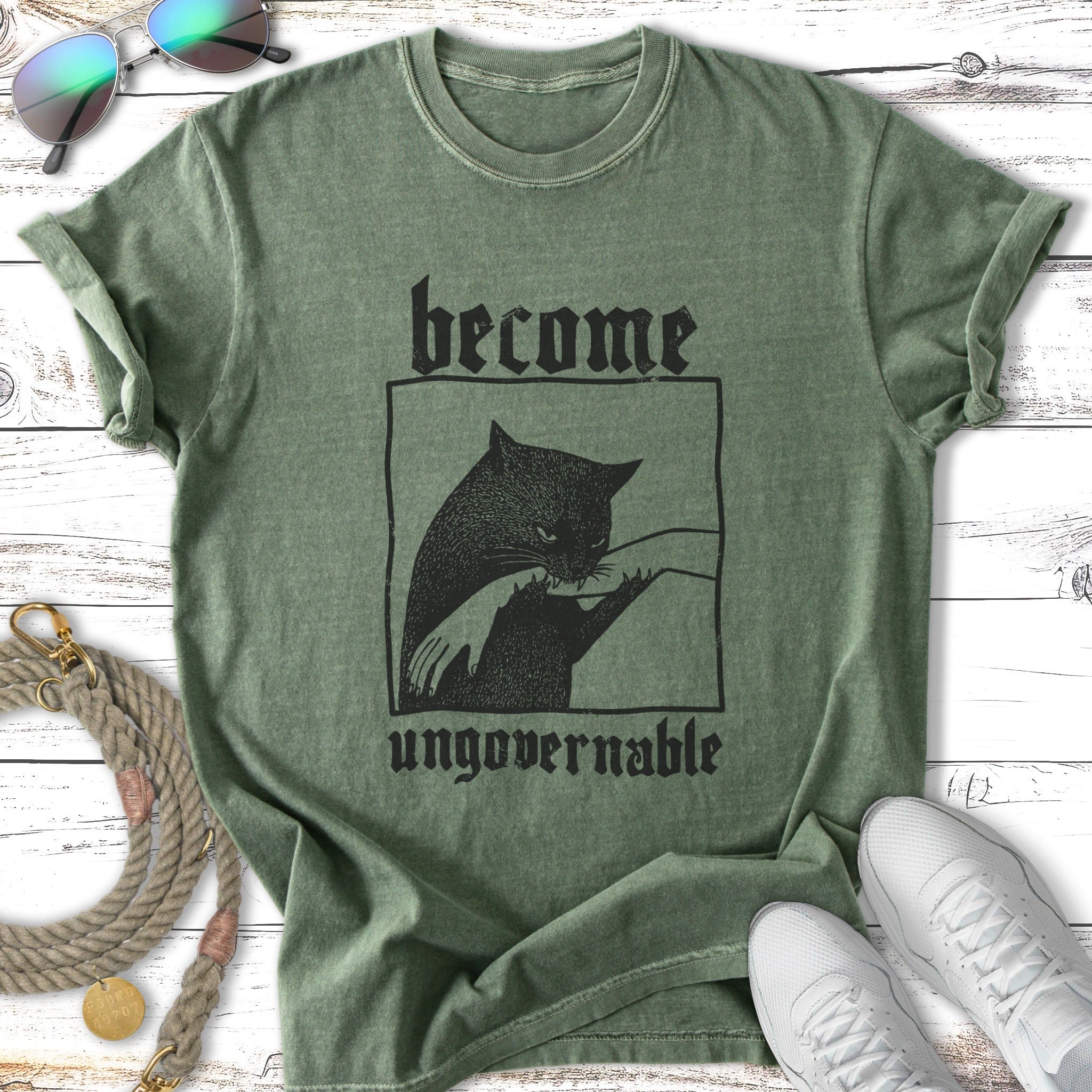 Green t-shirt with black cat graphic and "become ungovernable" text.