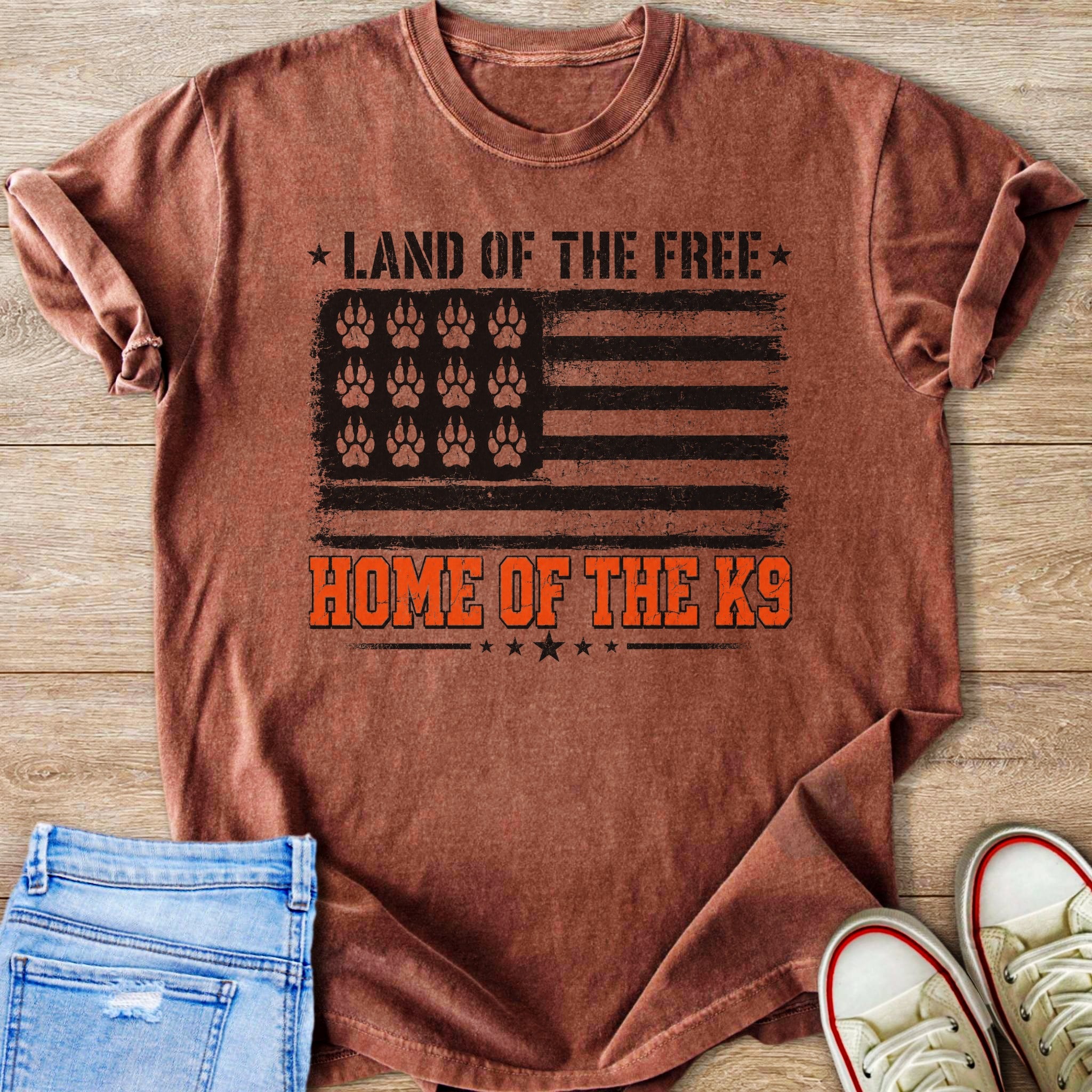 Rusty brown t-shirt with distressed American flag graphic featuring paw prints and text.