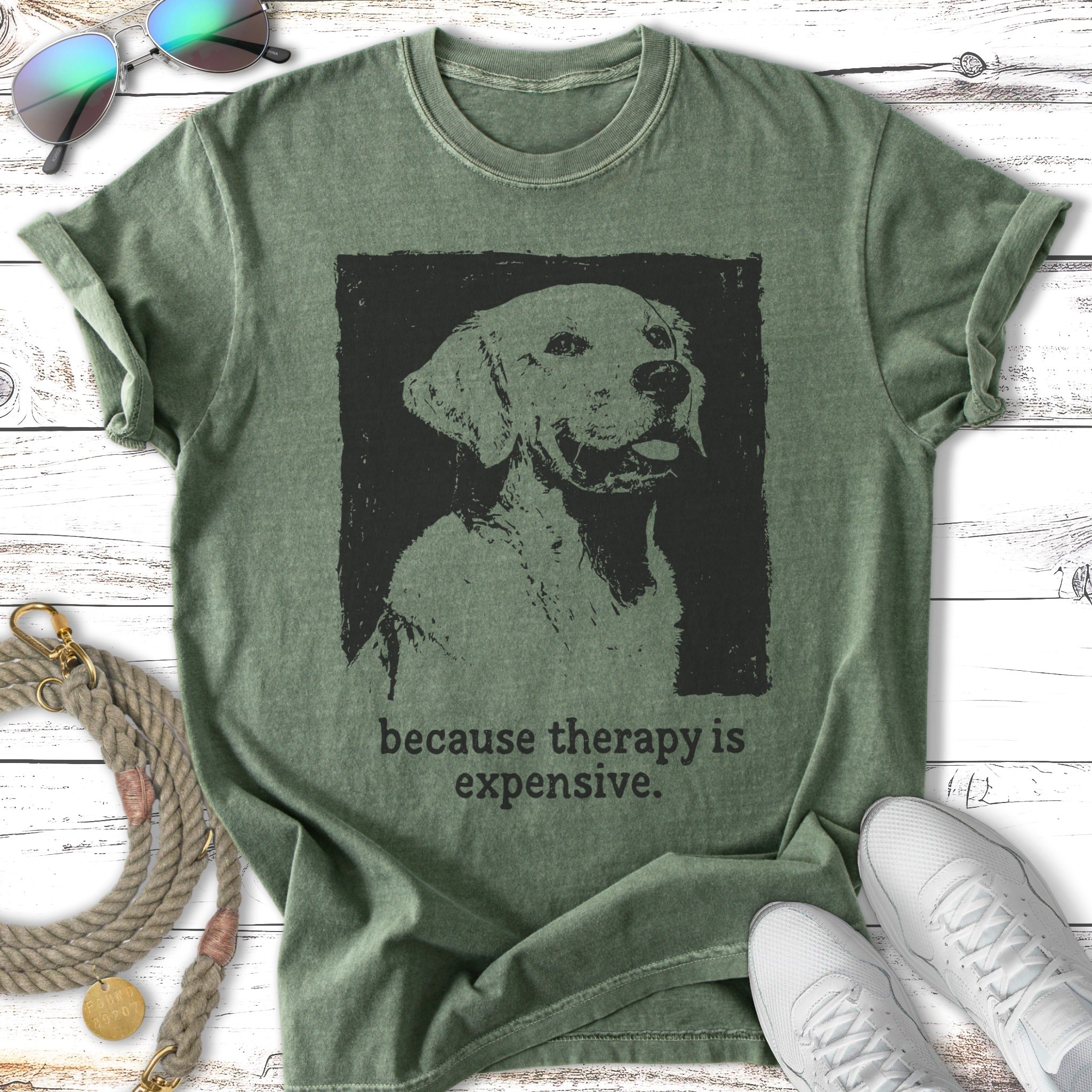 Green t-shirt with a black silhouette of a dog and the text "because therapy is expensive."