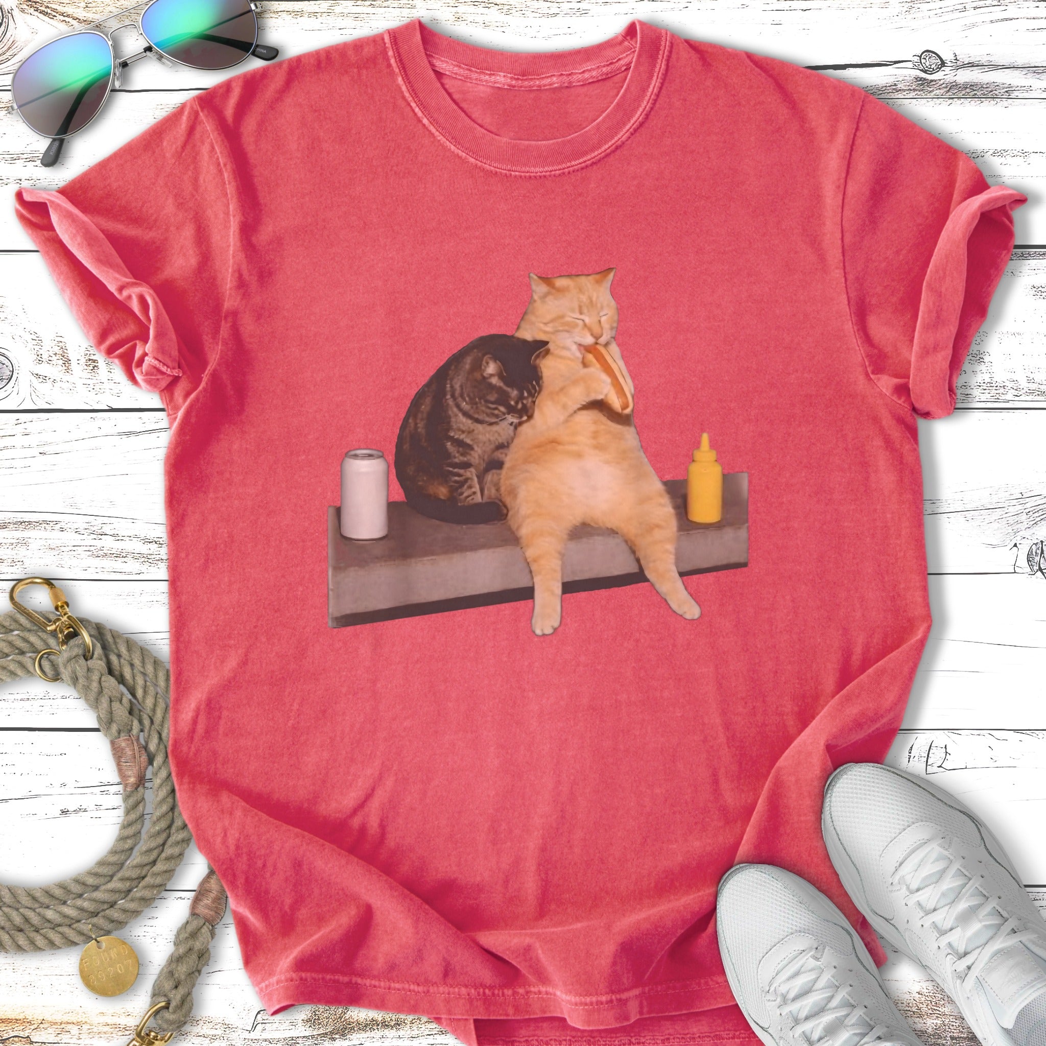 Cats hugging over a hot dog on a coral t-shirt.