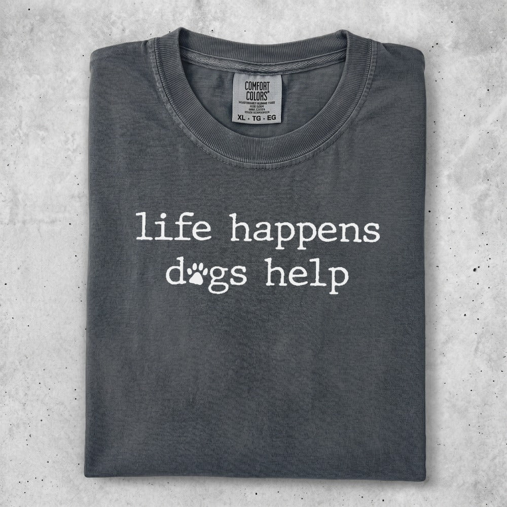 Dark grey t-shirt with "life happens dogs help" printed in white text.