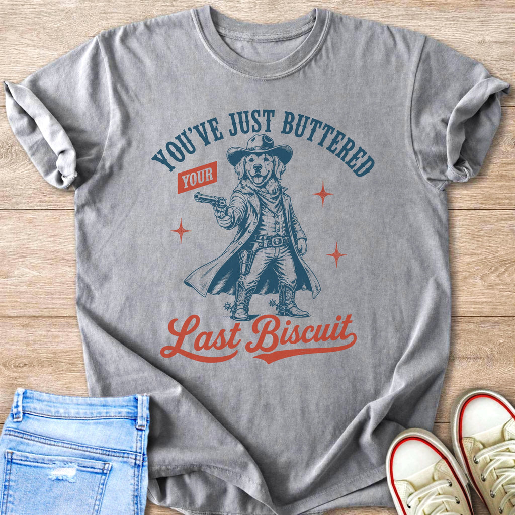T-shirt with graphic of a dog in cowboy attire holding a gun and text "You've Just Buttered Your Last Biscuit."